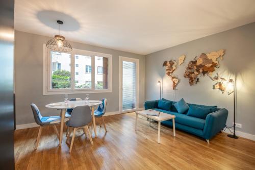 un salon avec un canapé bleu et une table dans l'établissement Geranimus logis Versaillais, à Versailles