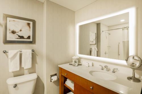 a white bathroom with a sink and a mirror at DoubleTree by Hilton Atlanta Airport in Atlanta