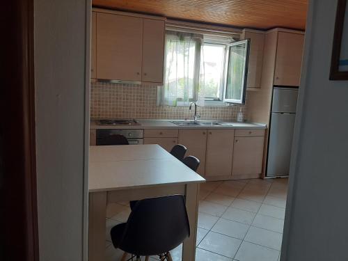 een keuken met een tafel en stoelen en een wastafel bij Christina Apartment in Ágios Konstantínos