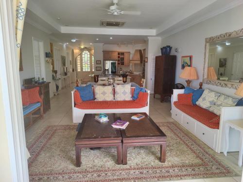 a living room with two couches and a coffee table at Queen Angel Suite. Stunning Apartment on Grafton Beach with Direct Beach Access in Black Rock