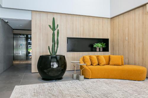 sala de estar con sofá amarillo y planta en Predio perto a ponte Hercilio Luz com piscina no centro de Floripa - Top Vision, en Florianópolis