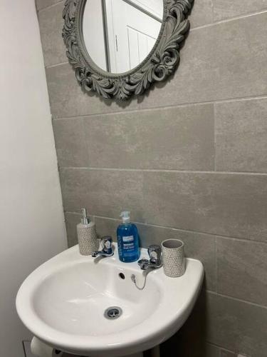 a bathroom with a sink and a mirror at Comfortable & Spacious Apartment in Stoke on Trent