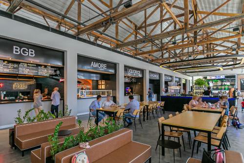 un groupe de personnes assises à des tables dans un restaurant dans l'établissement Studios Tower by Viva - Prédio com piscina e estacionamento no centro de Floripa, à Florianópolis
