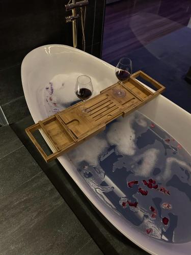 two glasses of wine in a bath tub with snow at Khánh Nguyễn Luxury studio, balcony street view, large bathtub in Ho Chi Minh City