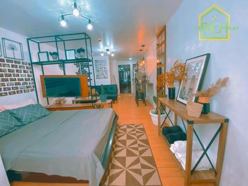 ein Schlafzimmer mit einem Bett und ein Wohnzimmer in der Unterkunft Cozy Condo in Marilao Bulacan - TRP10 in Marilao