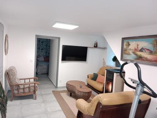 un salon rempli de meubles et d'une télévision à écran plat dans l'établissement Appartement en pleine nature, à champis