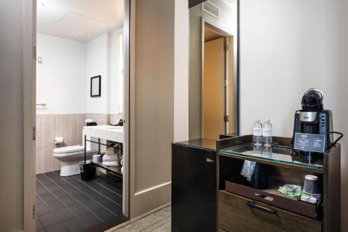 een hotelkamer met een badkamer met een wastafel bij The Richardson Hotel in Buffalo
