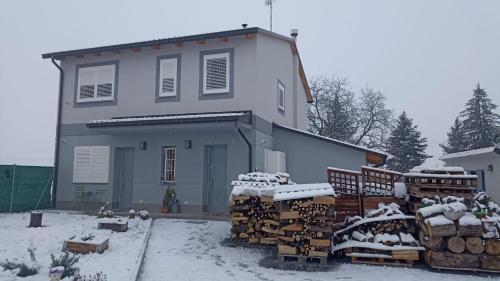 una casa con un montón de madera en la nieve en Appartamento B&B Cà Betty en Sacerno