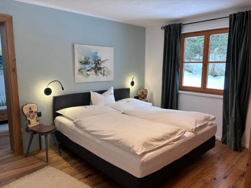 1 dormitorio con 1 cama grande con sábanas blancas en Haus Drescher, en Leutasch