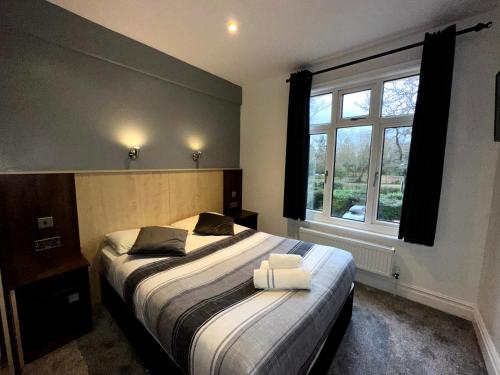 a bedroom with a bed and a window at Gainsborough Lodge in Horley