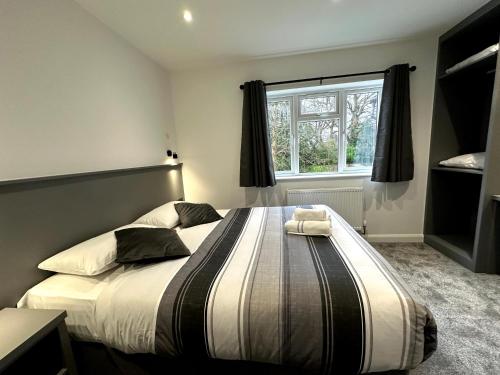 a bedroom with a large bed with a window at Gainsborough Lodge in Horley