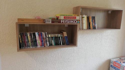 a book shelf filled with books on a wall at Seosko domaćinstvo Najdanović in Soko Banja