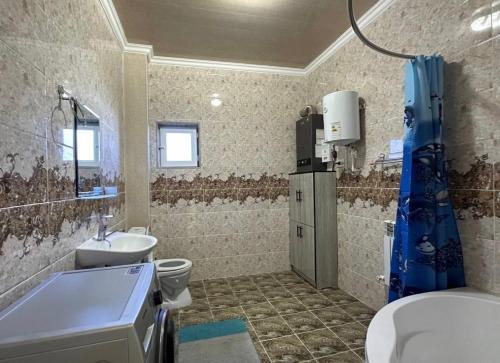 a bathroom with a sink and a toilet and a tub at Guest house "NIKA", Nukus in Nukus