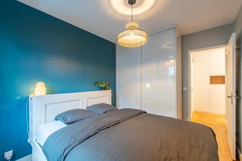 1 dormitorio con 1 cama con pared azul en Geranimus logis Versaillais en Versailles