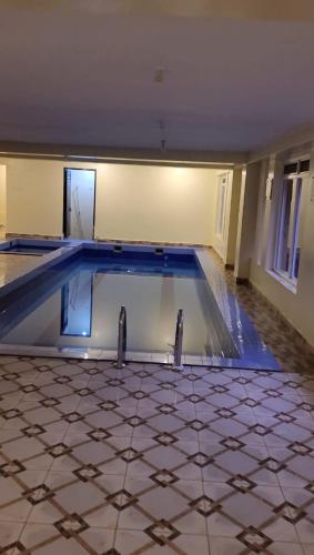 an empty swimming pool in a house at Dora's Apartment in Kampala