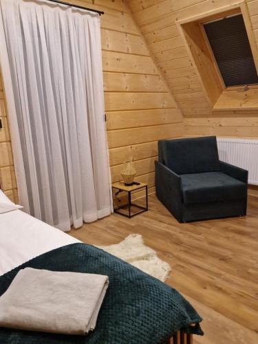 a bedroom with a bed and a chair at Chochołowski Zakątek in Chochołów