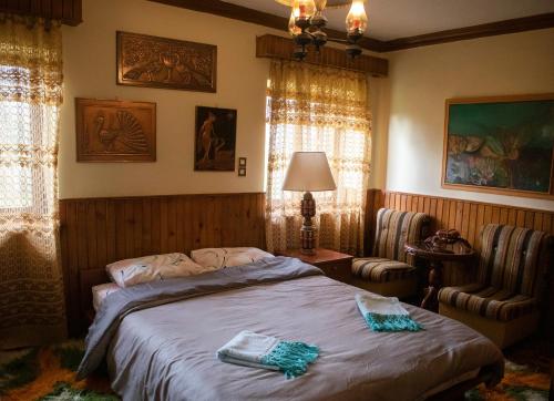 a bedroom with a bed and two chairs at Mouria County House in Tríkala