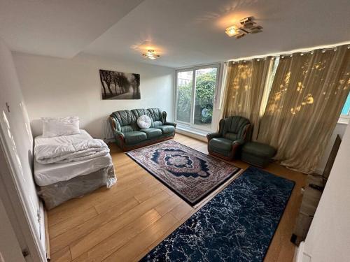 a living room with a couch and a chair at 3 bedroom garden house Maida Vale in London