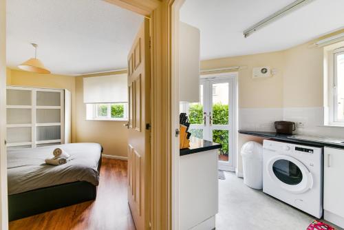 a bedroom with a bed and a washing machine at Amazing apartment in Canada Water - Free parking in London
