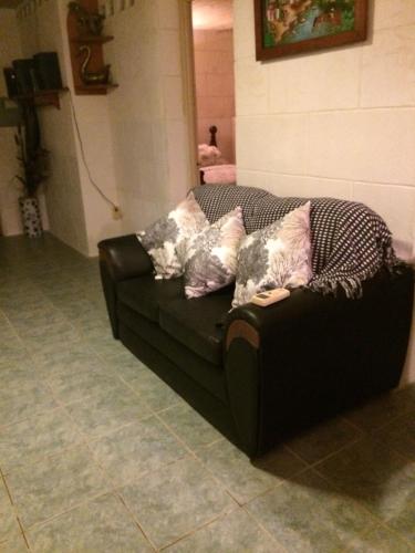 a black couch with many pillows on it at Oceanfront 2 bedroom apartment in Saint Philip