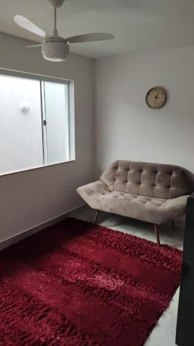 uma sala de estar com um sofá e um tapete vermelho em Oceano Residence em Búzios