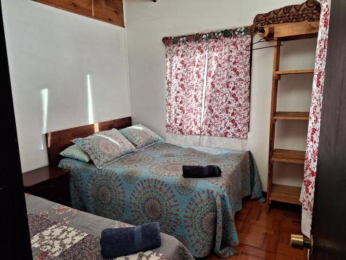 Habitación pequeña con cama y ventana en Cabañas puna poho, en Hanga Roa
