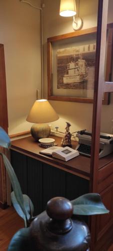 een bureau met een lamp en een foto van een boot bij Hostal Dinamarca in Valparaíso