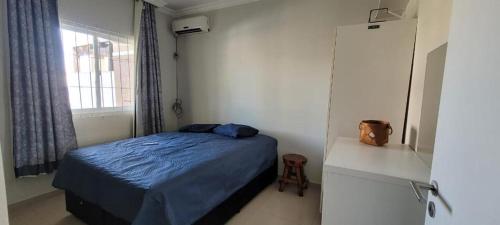 a bedroom with a blue bed and a window at Casa, mar e paz in Palhoça