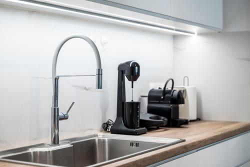 a kitchen counter with a sink and a kitchenilit at Casa Lemonia - 110 sqm Maisonette in Kardamaina