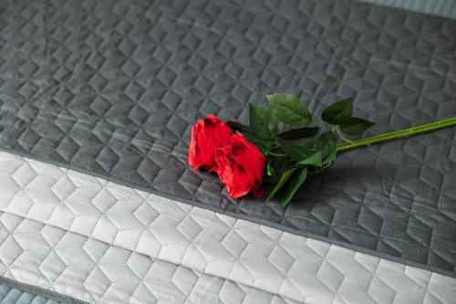 a red rose sitting on top of a bed at Apartma Ella in Lovrenc na Pohorju