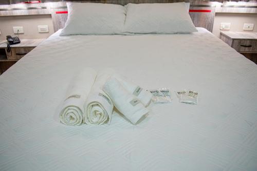 a white bed with towels and rings on it at Hotel Rio Dorado in Encarnación