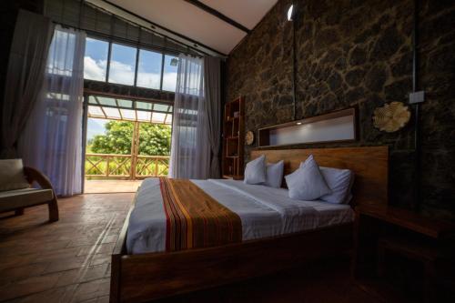 um quarto com uma cama e uma grande janela em Imbogo Diners and Lounge em Kisoro
