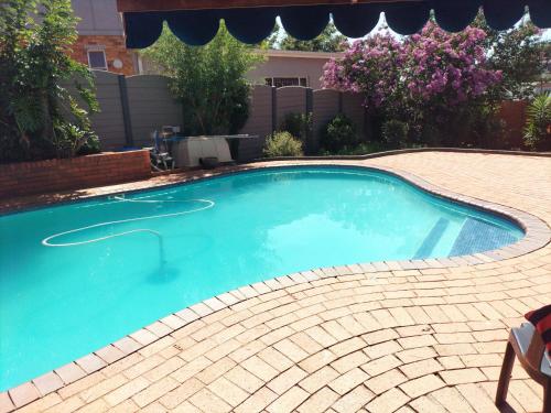 a swimming pool in a yard with a brick floor at The protea nest in Johannesburg