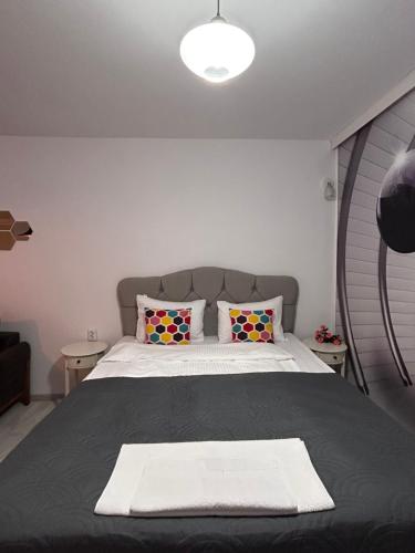 a bedroom with a bed with a black blanket and pillows at Apartment Fire & Lux near the center in Razgrad