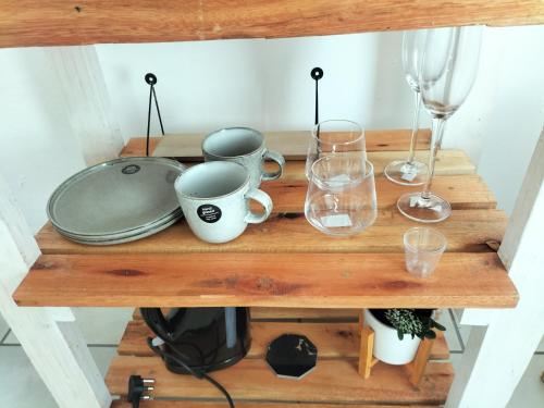a wooden shelf with glasses and wine glasses at The protea nest in Johannesburg