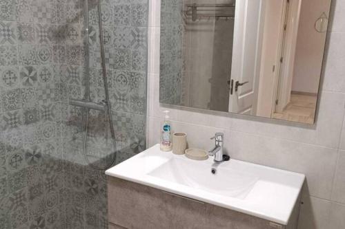 a bathroom with a sink and a shower with a mirror at Apartamento con vistas al mar in Fuengirola