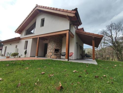 Casa blanca con porche y césped en Reguero Gato, Apartamentos Rurales 3 llaves en Candamo