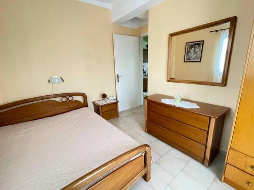 1 dormitorio con cama, tocador y espejo en Marithea apartment, en Pefkohori