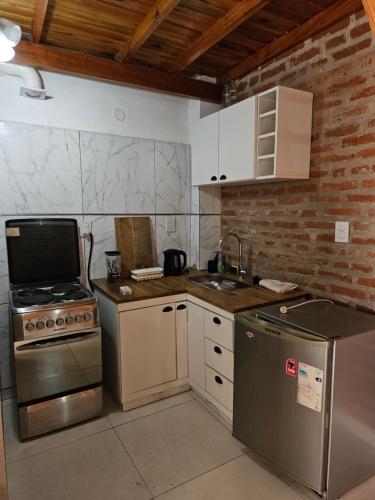 a small kitchen with a stove and a sink at Acogedor loft estilo industrial in Posadas