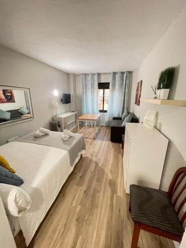 セビリアにあるResitur Luxury Suit 423のベッドルーム1室(ベッド1台付)、リビングルームが備わります。