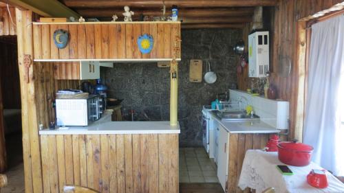 una piccola cucina con lavandino e forno a microonde di Casa Rustica a pasos de la playa a El Quisco