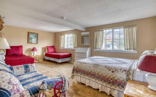 a bedroom with a bed and a couch and a chair at Anchors Aweigh in Lincoln City