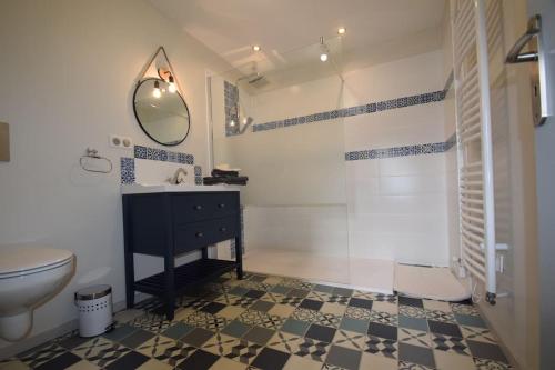 uma casa de banho com um lavatório, um WC e um espelho. em Gîte de Bena em Chaunay