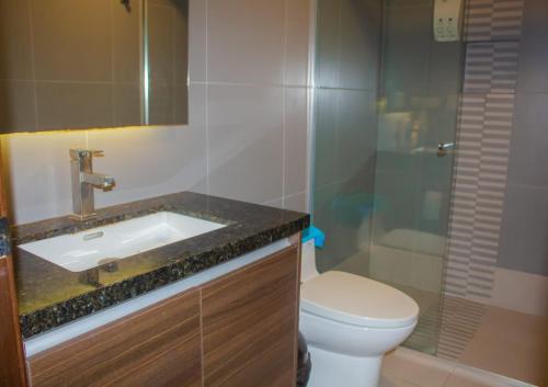 Un baño con lavabo, inodoro y ducha. en Hermosa Vista Lateral al Mar Edif. Poseidon, en Manta