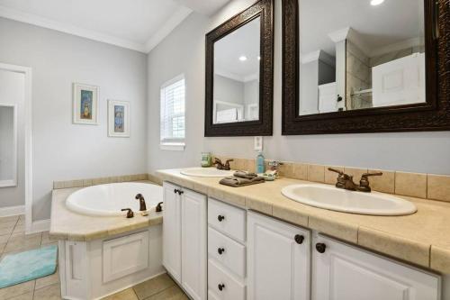 a bathroom with two sinks and a mirror at Old Town Bay St. Louis Outdoor Bar Area Game Room in Bay Saint Louis