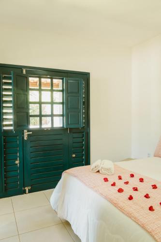 a bedroom with a bed with red roses on it at Villa Nova Holanda in Guaramiranga