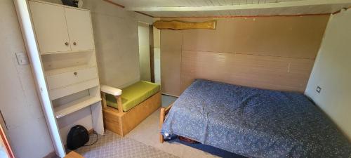 Dormitorio pequeño con cama y armario en Pieza y estacionamiento independiente en Panguipulli