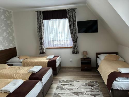 Zimmer mit 3 Betten und einem Fenster in der Unterkunft Willa u Bacy in Leśnica