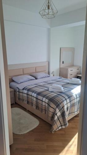 1 dormitorio con 1 cama con manta y espejo en Аэропорт Апартаменты Комфорт en Chişinău