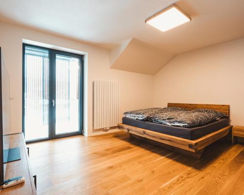 - une chambre avec un lit et une grande fenêtre dans l'établissement Molo Lipno resort luxusní apartmán 4kk, à Český Krumlov